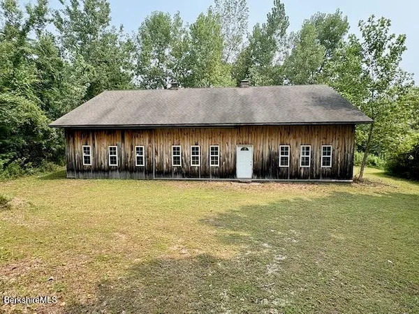 a front view of a house with a garden and tree
