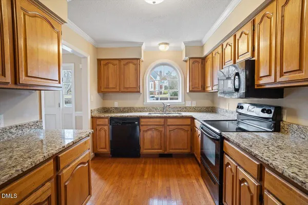 a kitchen with stainless steel appliances granite countertop a sink stove and cabinets