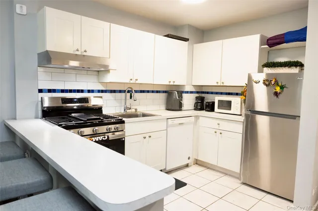 a kitchen with white cabinets and appliances