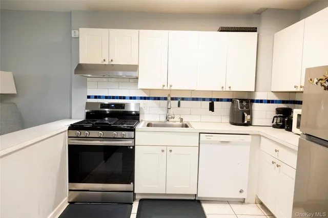 a kitchen with cabinets appliances a sink and a window