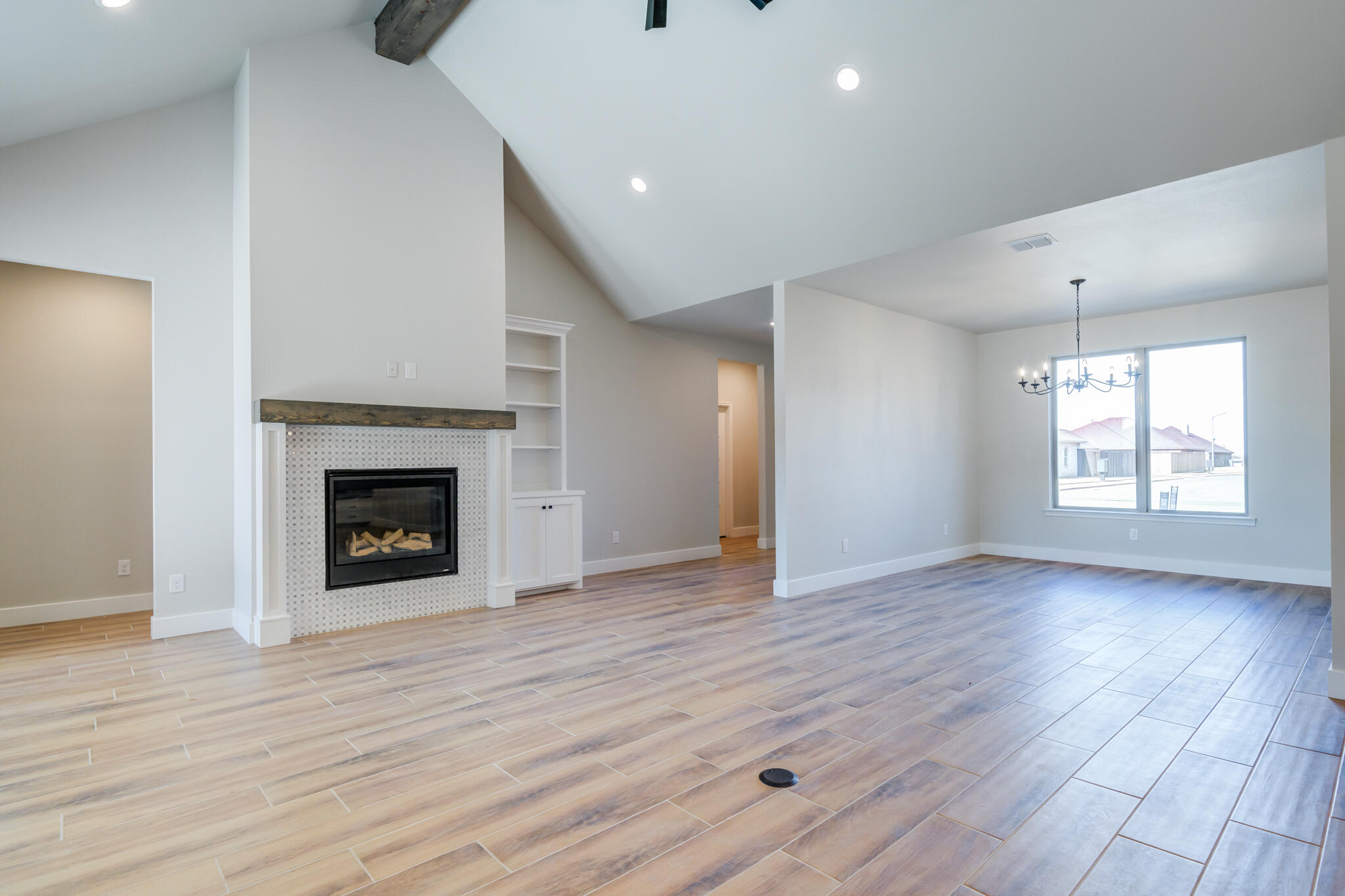 7805 54th Street Lubbock, TX 79407 - Photo 19 of 55 a view of an empty room with wooden floor fireplace and a window