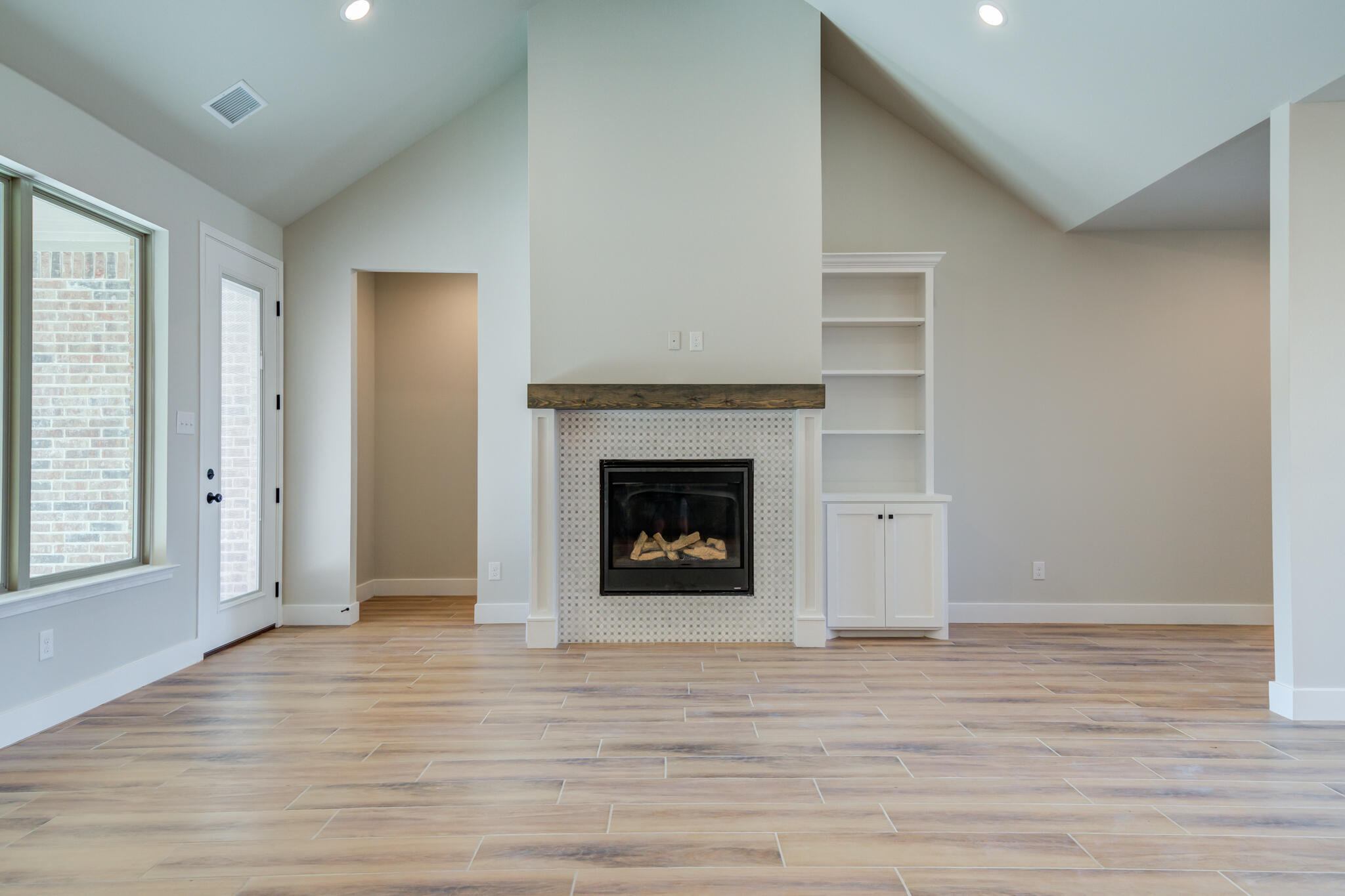 7805 54th Street Lubbock, TX 79407 - Photo 21 of 55 wooden floor fireplace and window in an empty room
