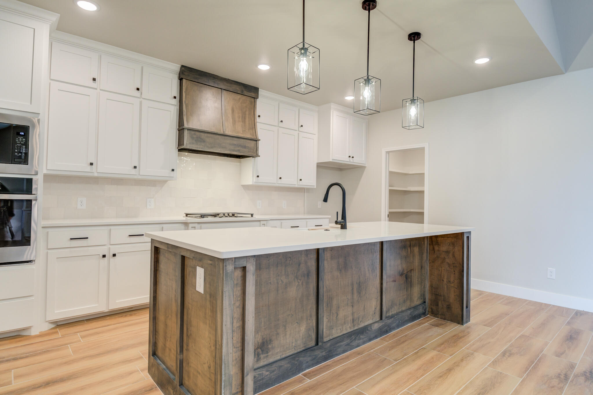 7805 54th Street Lubbock, TX 79407 - Photo 23 of 55 a kitchen with kitchen island a sink stainless steel appliances and cabinets
