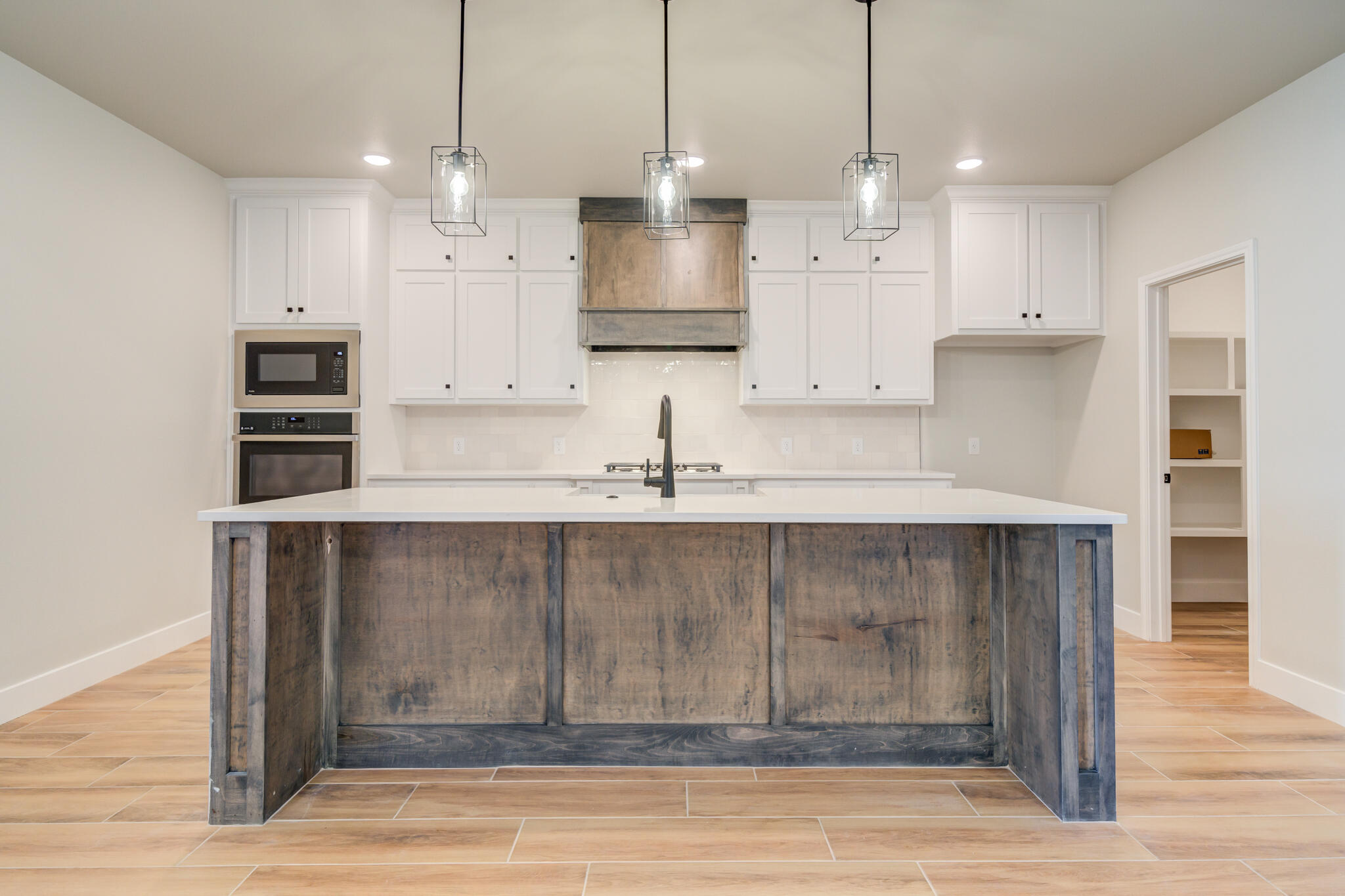 7805 54th Street Lubbock, TX 79407 - Photo 24 of 55 a kitchen with kitchen island white cabinets and refrigerator