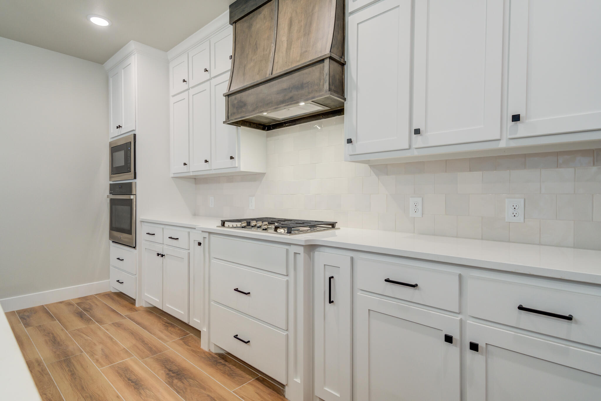 7805 54th Street Lubbock, TX 79407 - Photo 26 of 55 a kitchen with white cabinets and white appliances