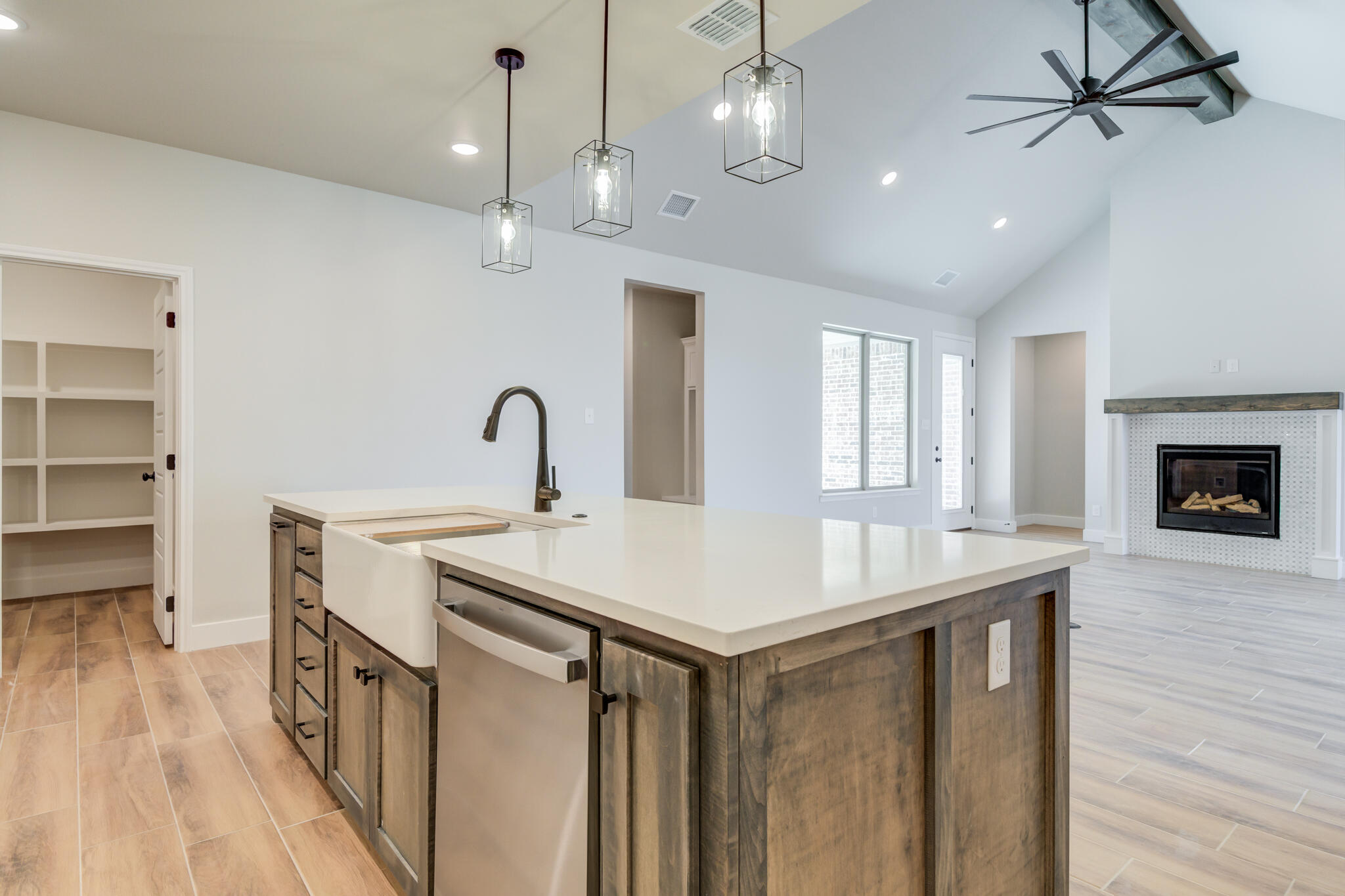 7805 54th Street Lubbock, TX 79407 - Photo 29 of 55 a kitchen with a sink a chandelier stainless steel appliances and cabinets