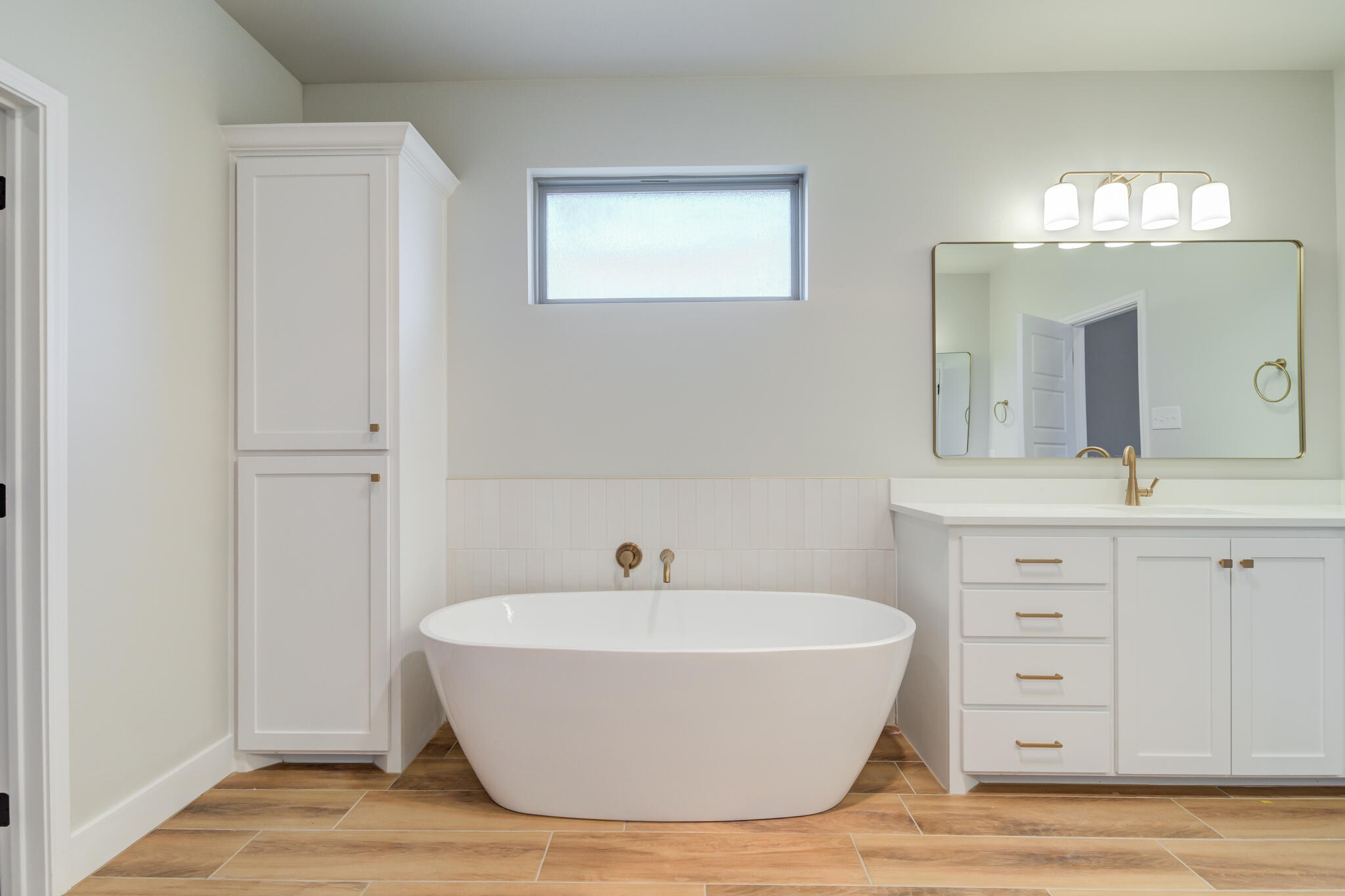 7805 54th Street Lubbock, TX 79407 - Photo 50 of 55 a bathroom with a white tub shower and a mirror