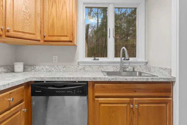 a kitchen with granite countertop a sink stainless steel appliances and cabinets