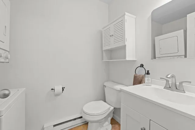 a view of kitchen and empty room with wooden floor