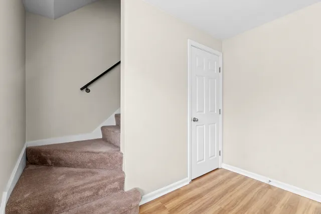 an empty room with wooden floor and entryway