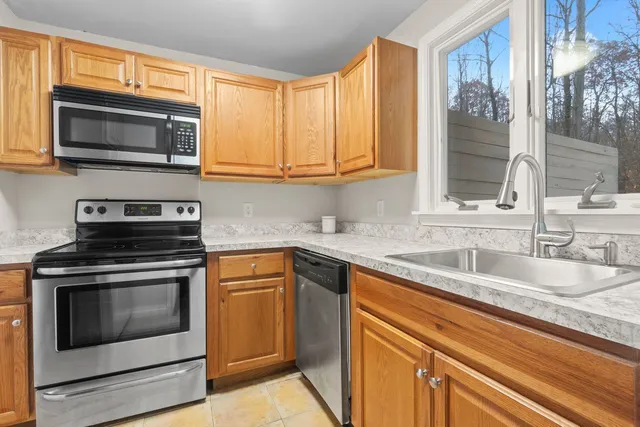 a kitchen with stainless steel appliances granite countertop a refrigerator a stove a sink and a microwave