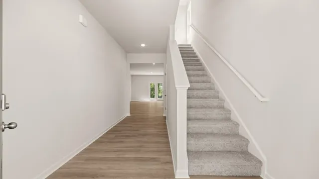 a view of entryway and gallery with wooden floor