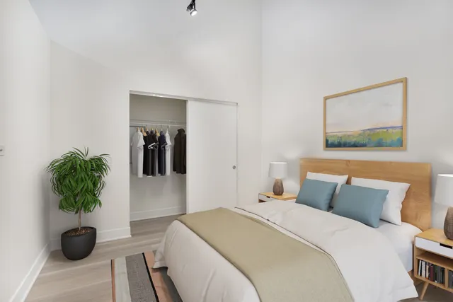 a bedroom with a bed and a potted plant