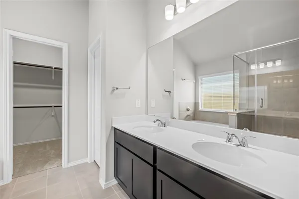 a bathroom with a double vanity sink a mirror and a shower