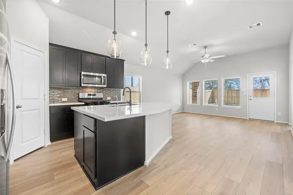 a kitchen with kitchen island a sink stainless steel appliances and counter space