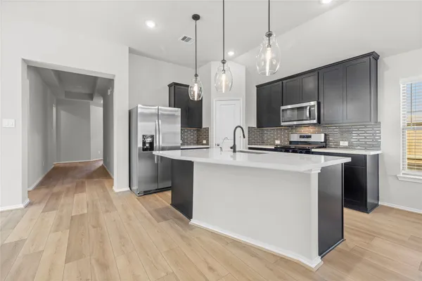 a kitchen with stainless steel appliances granite countertop a sink stove and refrigerator