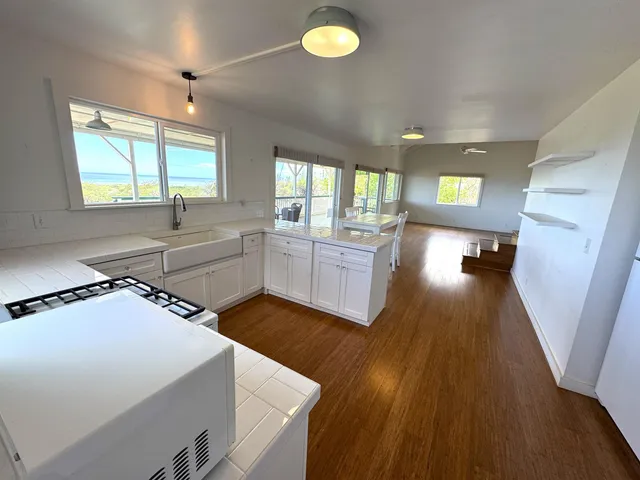 a kitchen with stainless steel appliances a stove a sink and a large window
