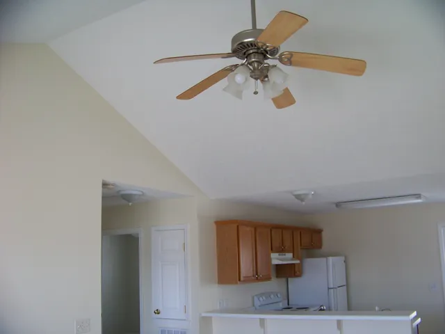 a view of kitchen with a refrigerator cabinets and a ceiling fan