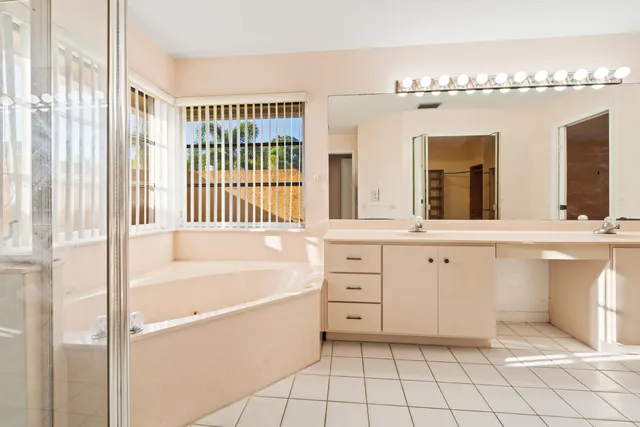 a bathroom with a tub sink and mirror
