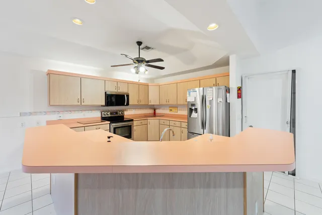 a large kitchen with kitchen island white cabinets and stainless steel appliances