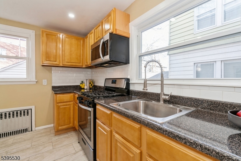 41 Poe Avenue Newark, NJ 07106 - Photo 26 of 44 a kitchen with stainless steel appliances granite countertop a sink stove and refrigerator
