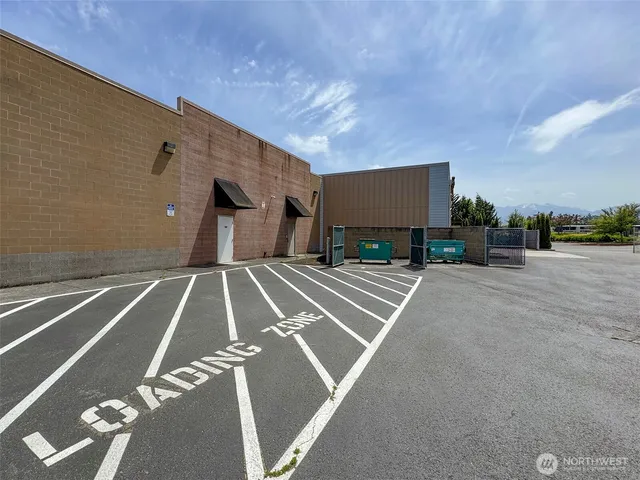 an aerial view of a city with lots of residential buildings and ocean view in back