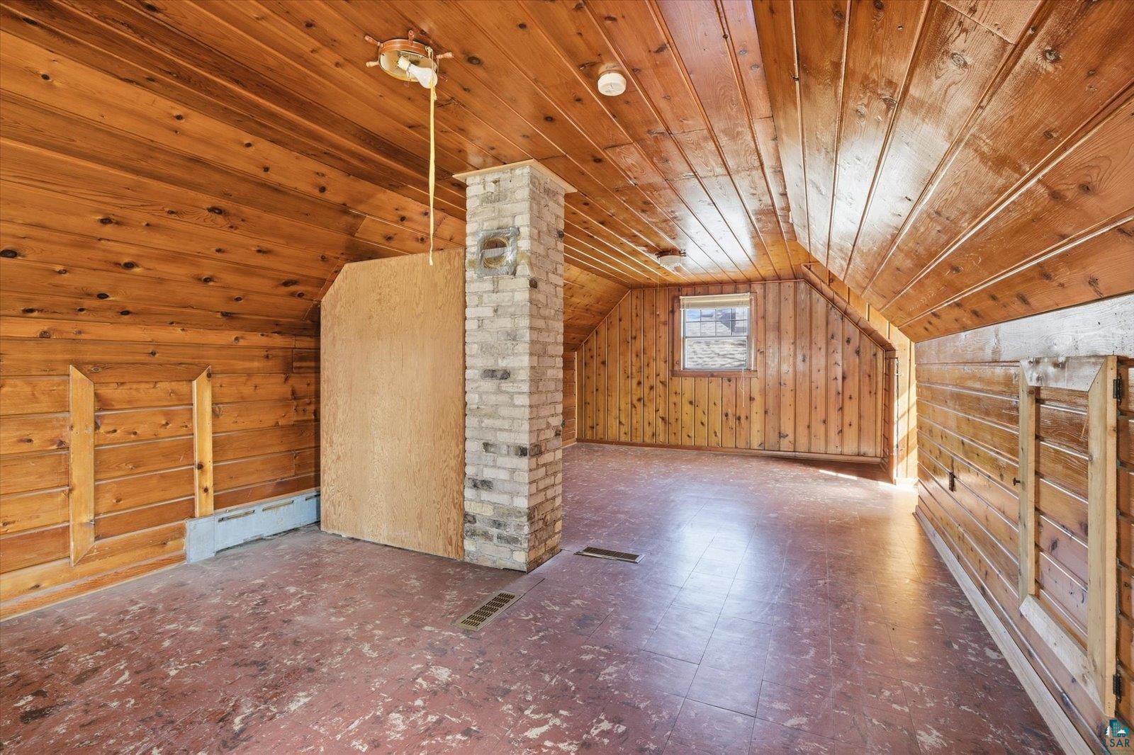 709 Michigan Street Hibbing, MN 55746 - Photo 15 of 47 Additional living space with tile patterned floors, a baseboard radiator, a vaulted wood ceiling, and wood walls