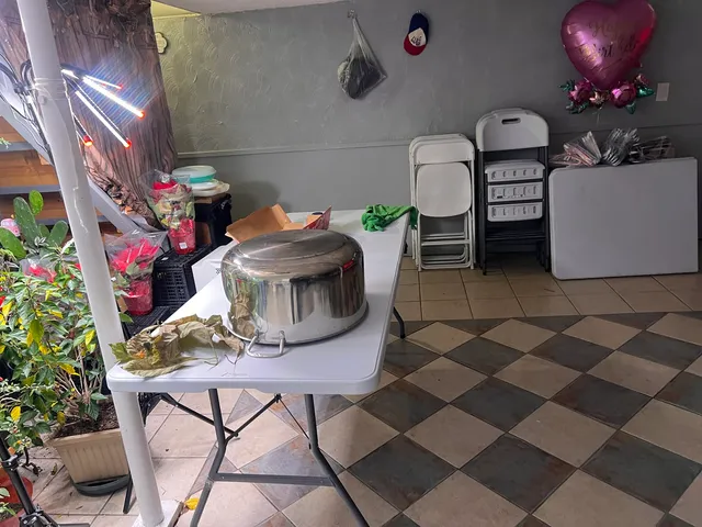a living room with a gaming machine and dining chairs
