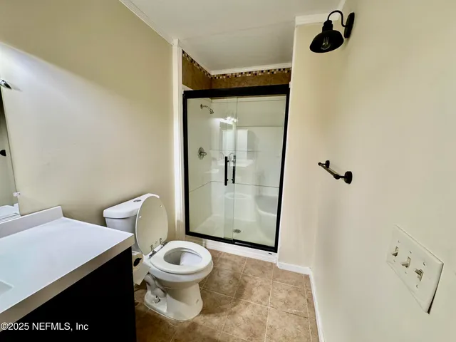 a bathroom with a granite countertop toilet and a shower
