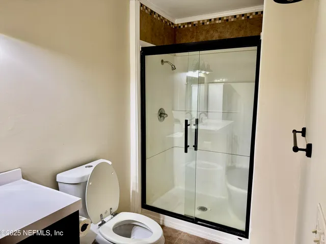 a bathroom with a toilet and a shower
