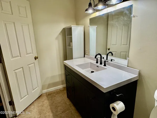 a bathroom with a sink vanity and a mirror