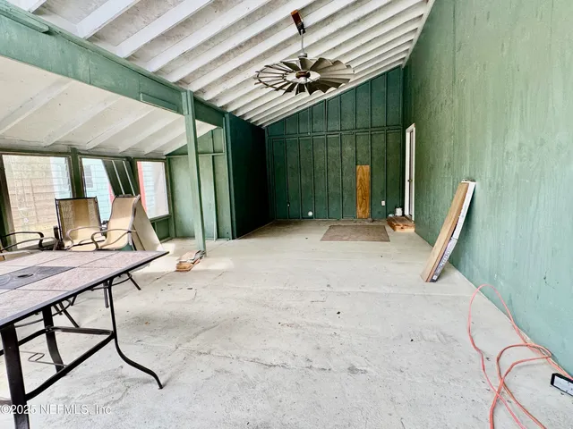 a view of a backyard with a table and chairs under an umbrella