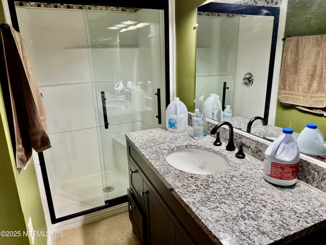 a bathroom with a granite countertop sink and a mirror