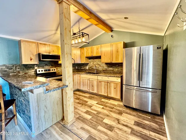 a kitchen with stainless steel appliances a refrigerator stove and microwave