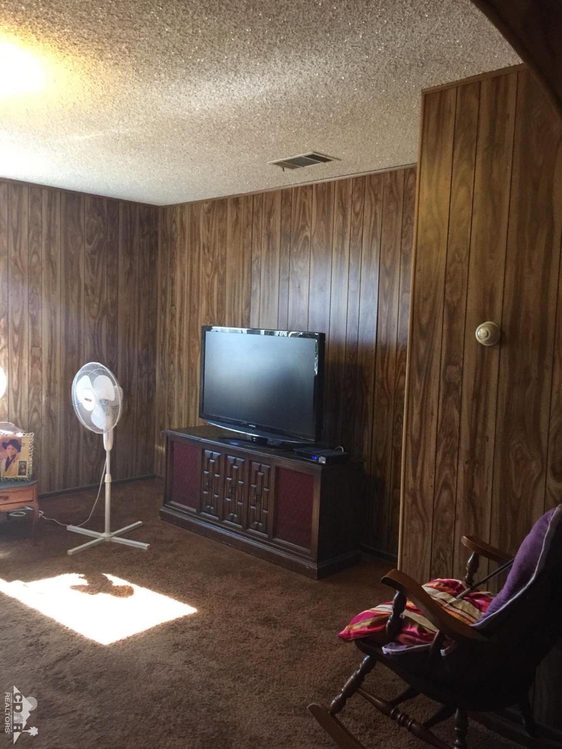 46751 Arabia Street Indio, CA 92201 - Photo 20 of 42 a living room with furniture a chandelier and a window