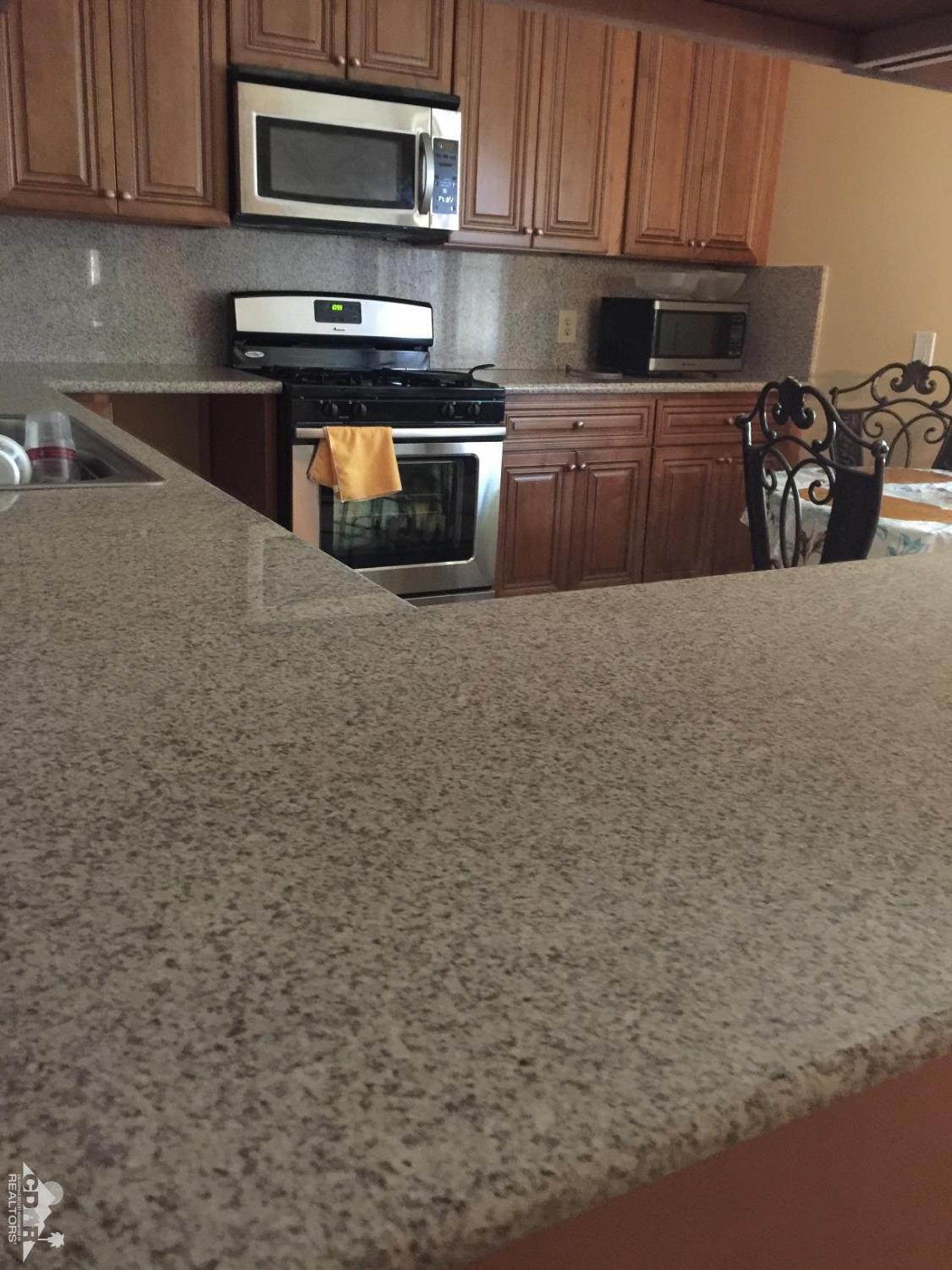 46751 Arabia Street Indio, CA 92201 - Photo 2 of 42 a kitchen with stainless steel appliances granite countertop a stove a sink and a microwave
