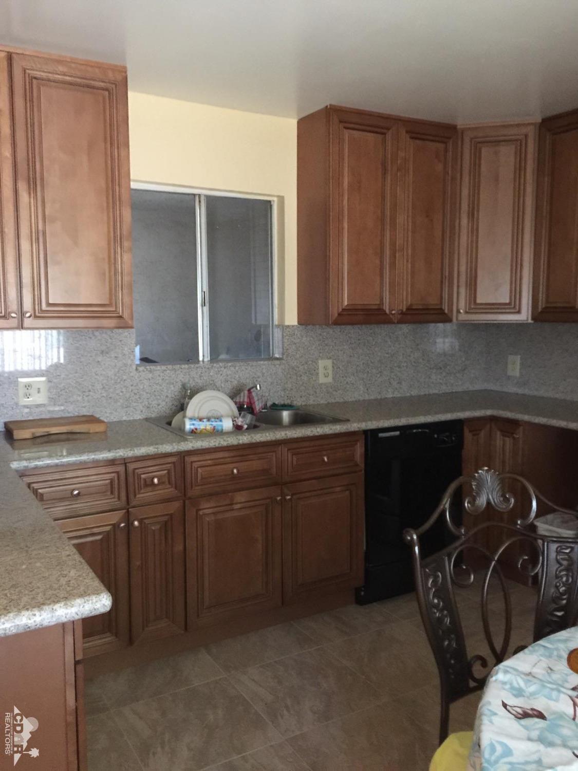 46751 Arabia Street Indio, CA 92201 - Photo 3 of 42 a kitchen with granite countertop a sink stove and cabinets