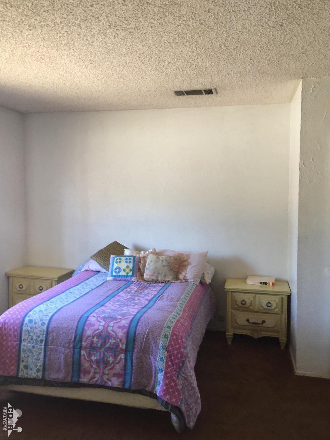 46751 Arabia Street Indio, CA 92201 - Photo 36 of 42 a bedroom with a bed and a night stand