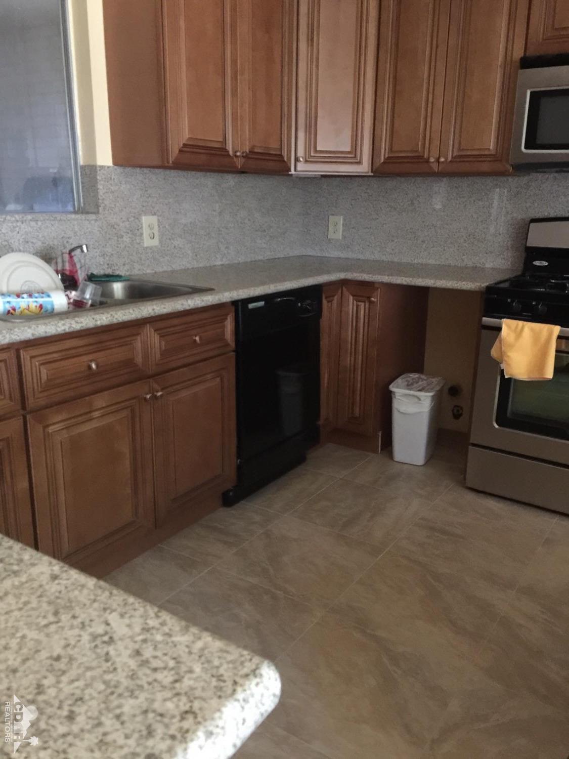 46751 Arabia Street Indio, CA 92201 - Photo 5 of 42 a kitchen with stainless steel appliances granite countertop a sink stove and microwave