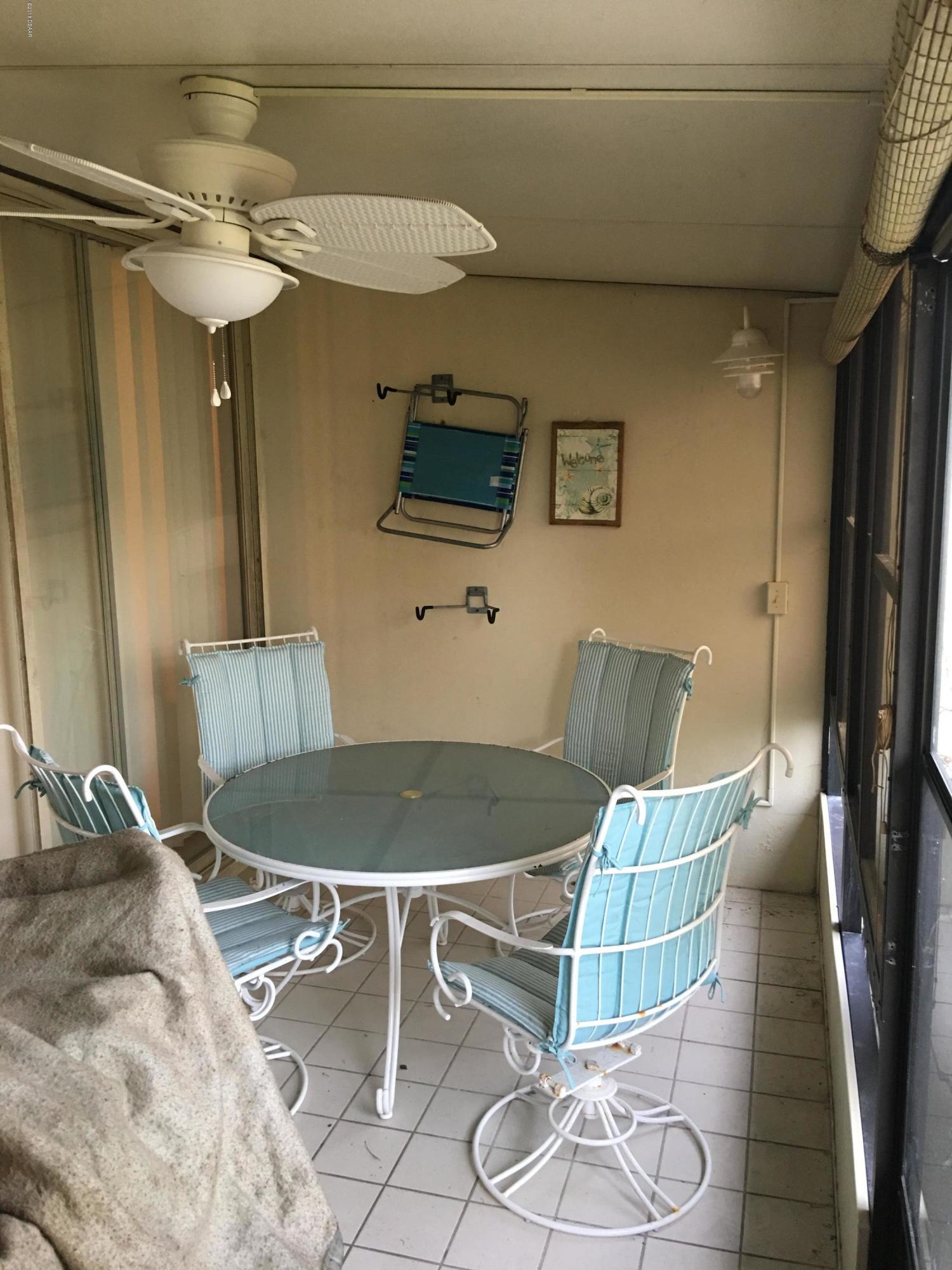 5500 Ocean Shore Boulevard, Unit 52 Ormond Beach, FL 32176 - Photo 14 of 33 a living room with a bed and a chandelier
