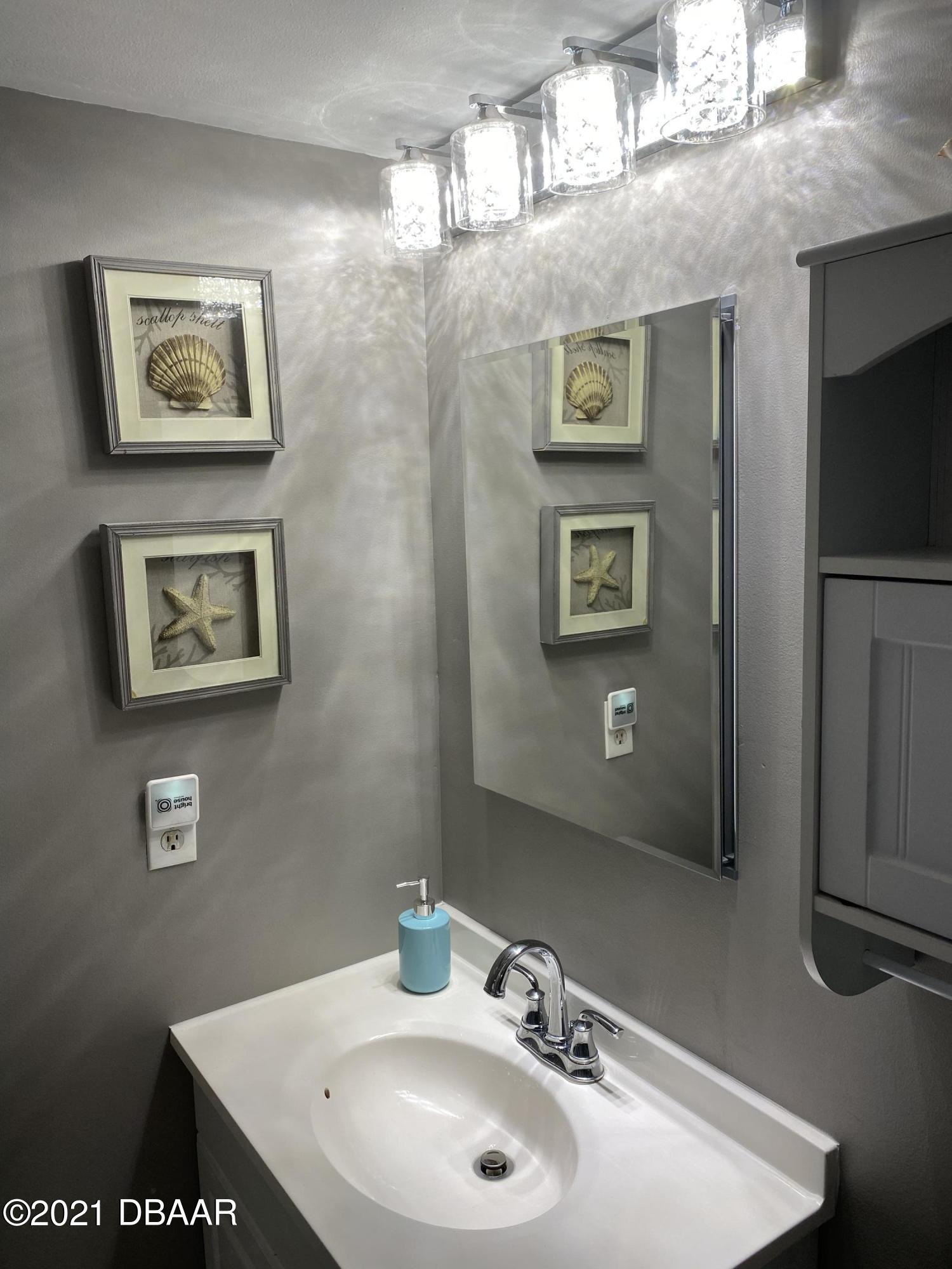 5500 Ocean Shore Boulevard, Unit 52 Ormond Beach, FL 32176 - Photo 22 of 33 a bathroom with a sink and a mirror