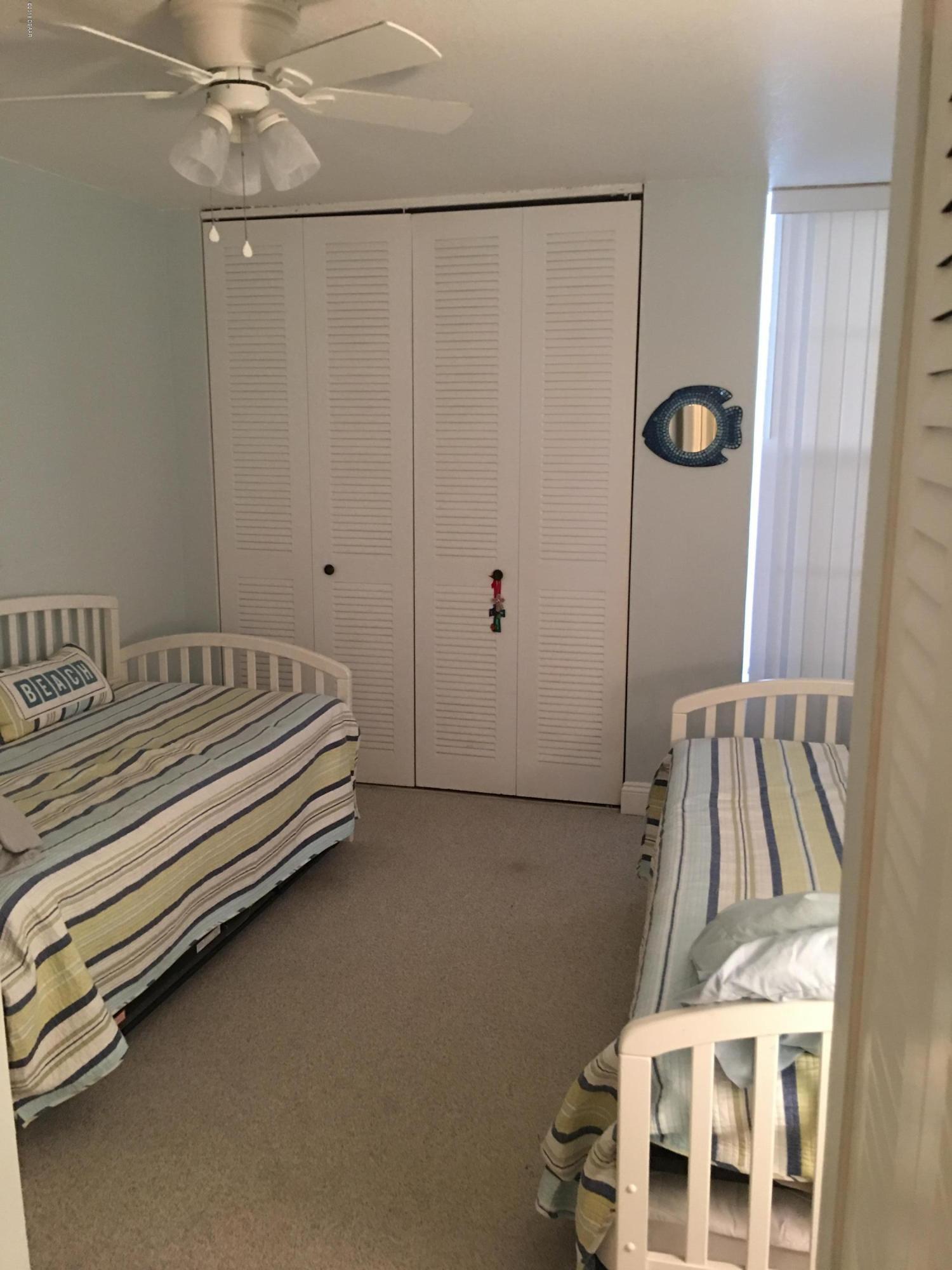 5500 Ocean Shore Boulevard, Unit 52 Ormond Beach, FL 32176 - Photo 26 of 33 a bedroom with a bed and a baby crib