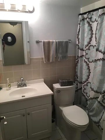 a bathroom with a granite countertop toilet sink and mirror