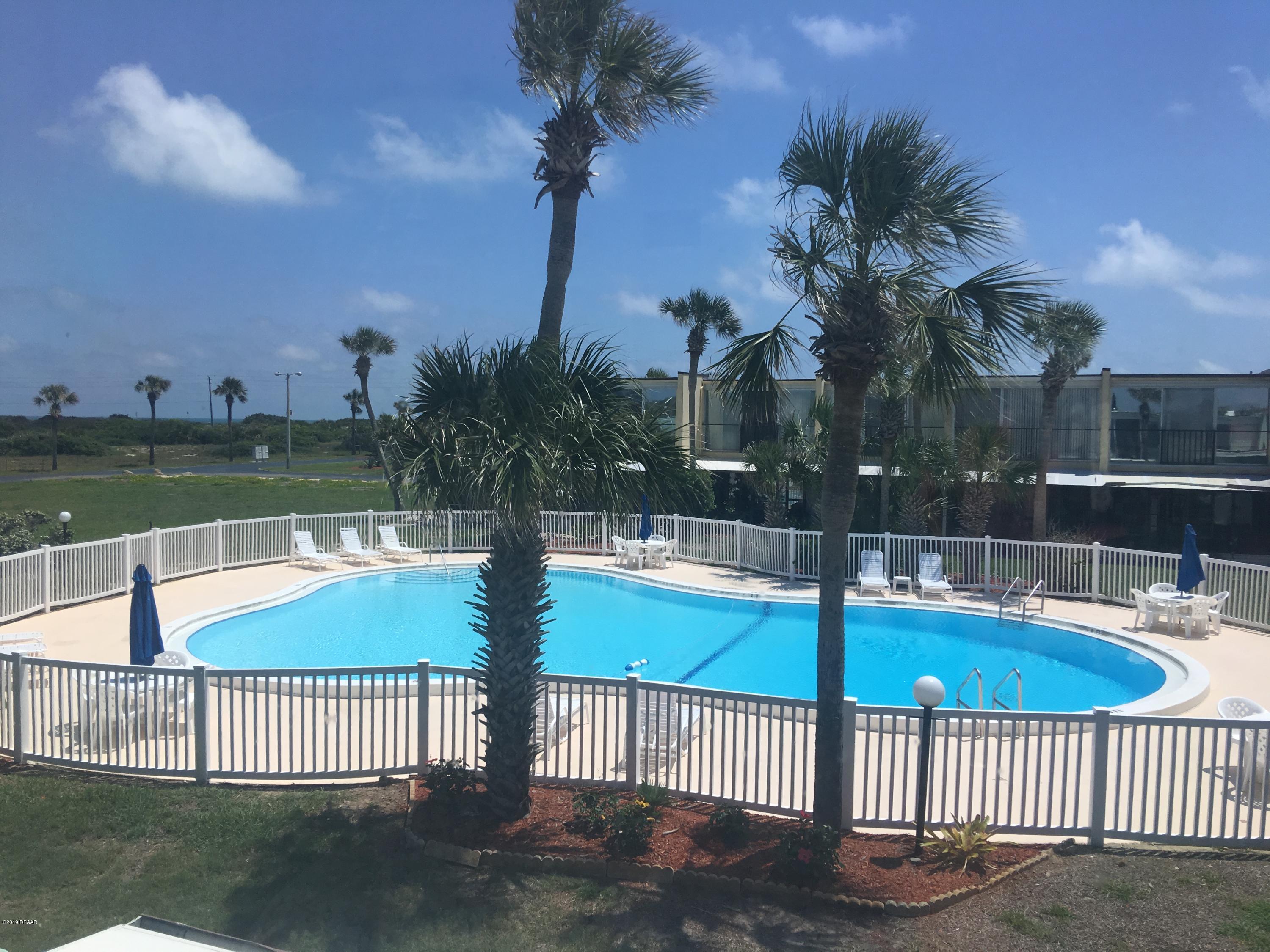 5500 Ocean Shore Boulevard, Unit 52 Ormond Beach, FL 32176 - Photo 32 of 33 a view of a swimming pool with a patio and a yard