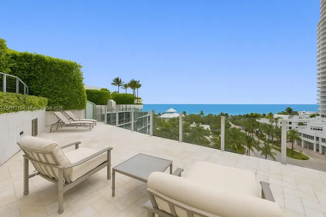 a view of a terrace with furniture and a garden