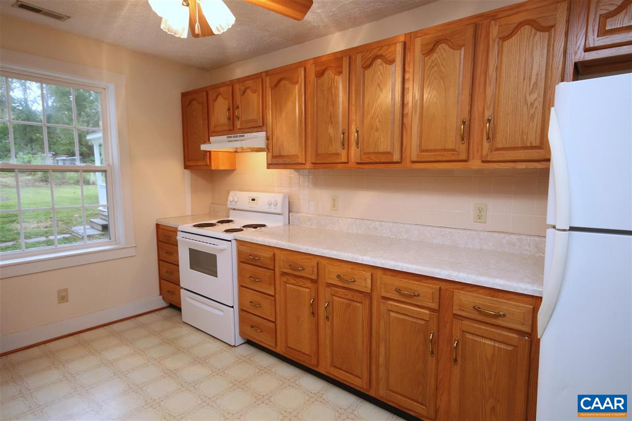 6773 Orange Road Orange, VA 22960 - Photo 9 of 31 a kitchen with granite countertop wooden cabinets and white appliances