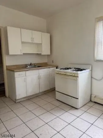 a kitchen with a stove sink and cabinets