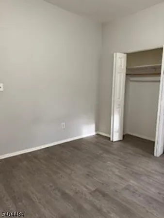 a view of an empty room with closet and a window