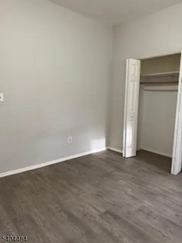 a view of an empty room with closet and a window