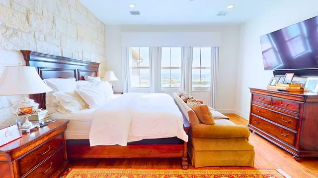 a bedroom with a bed and a lamp on dresser